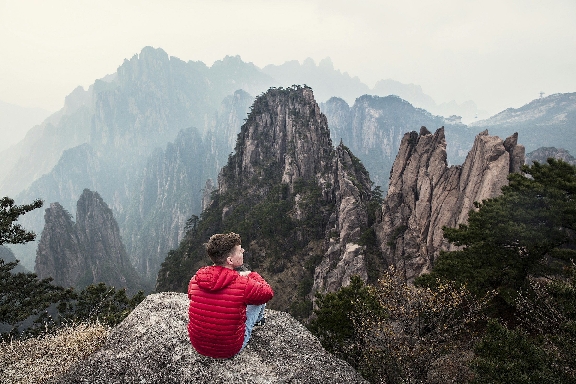 A traveler overlooking the granite peaks of Mount Huangshan